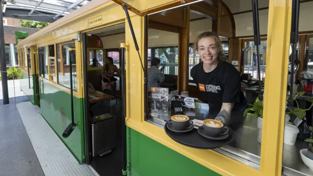 A modern tram in an Australian city with diverse food stalls
